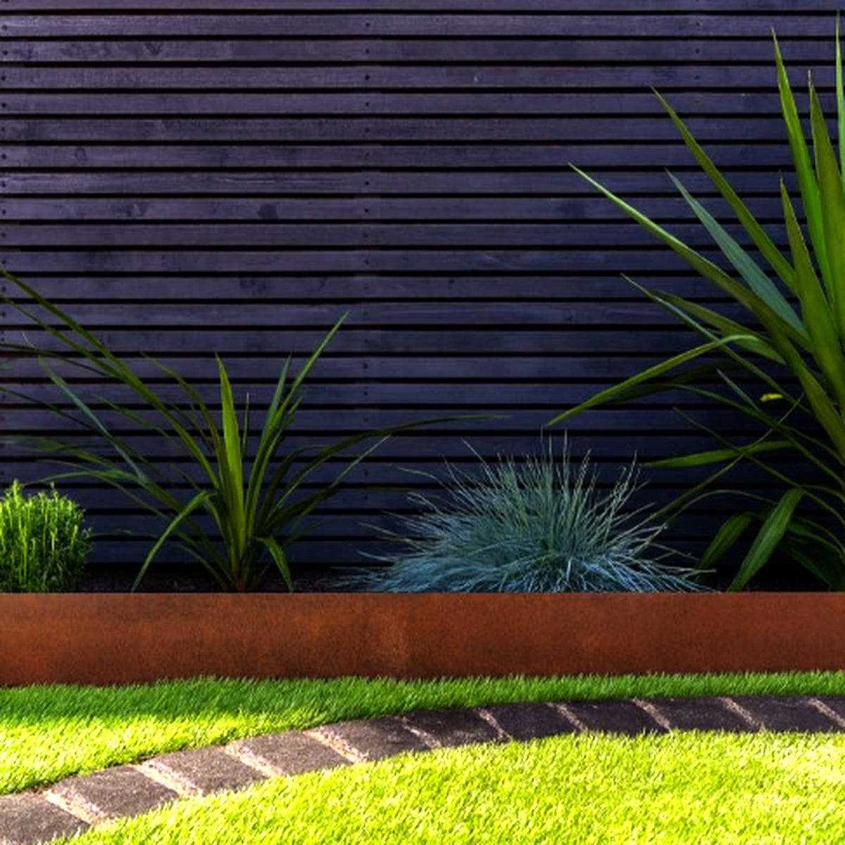 Corten steel lawn edging framing grass border against timber wall – contemporary garden design UK