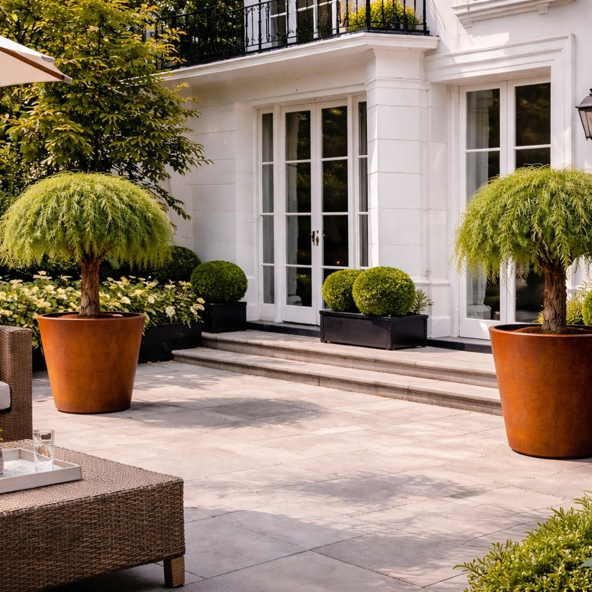 Pair of corten steel tapered planters on London townhouse terrace, luxury outdoor planters for residential gardens